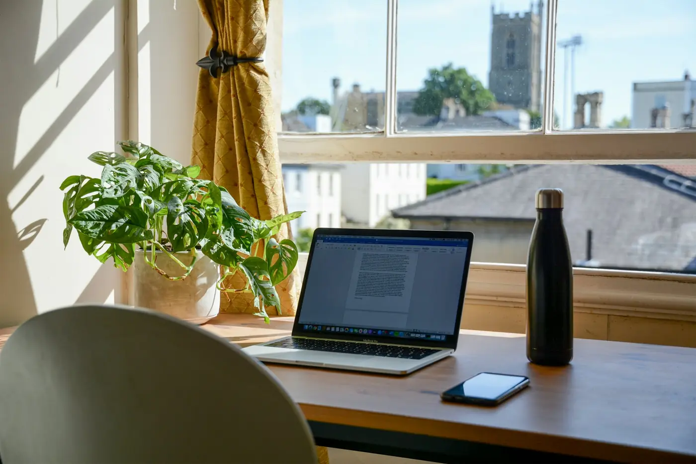 Ordinateur portable sur un bureau près d'une fenêtre